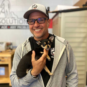 Eric holding a small dog and smiling